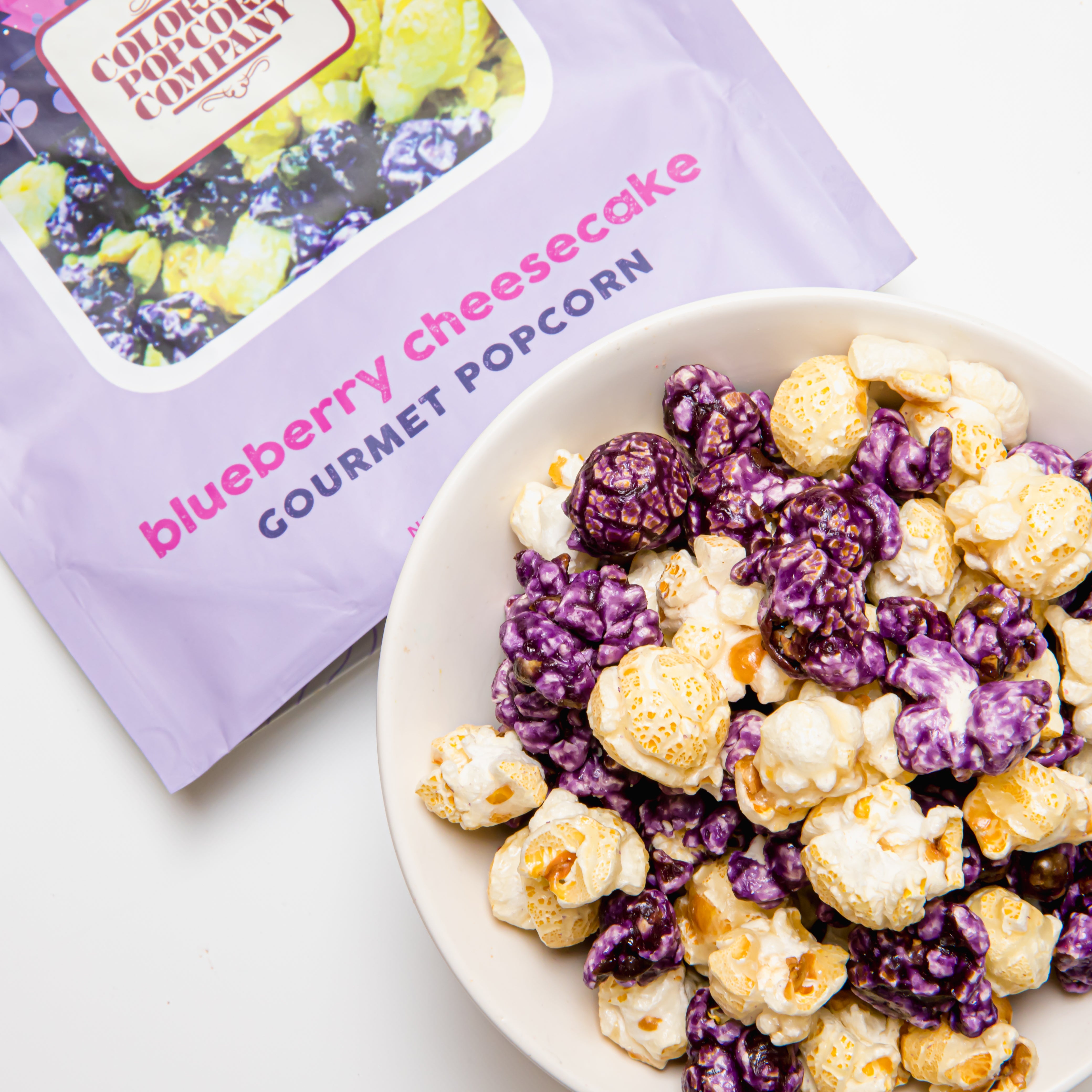 Blueberry Cheesecake Popcorn from Colorado Popcorn Company in a 5 oz bag, featuring blue popcorn coated with blueberry and cheesecake flavors.