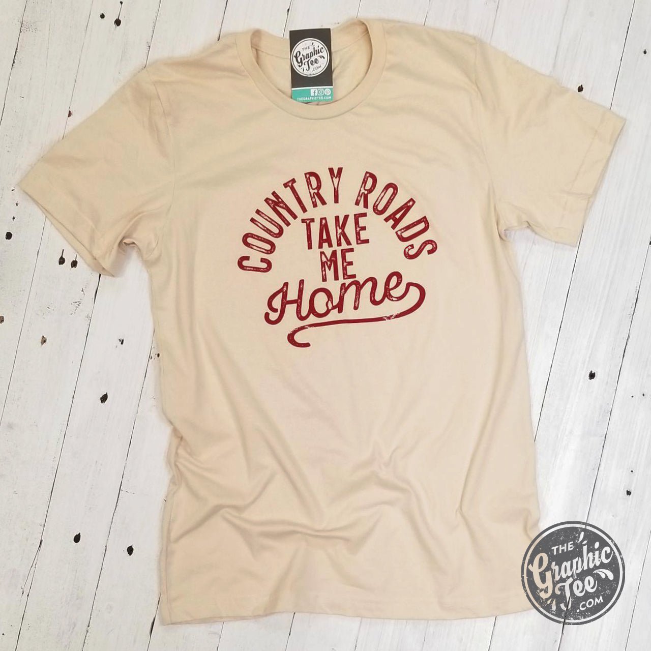 Unisex graphic T-shirt featuring "Country Roads Take Me Home" design from The Graphic Tee, displayed flat on a white background.