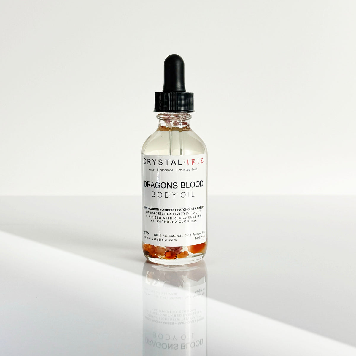 Crystal Irie Dragon's Blood Body Oil in a 2oz bottle, showcasing the vibrant red oil in a clear glass container.