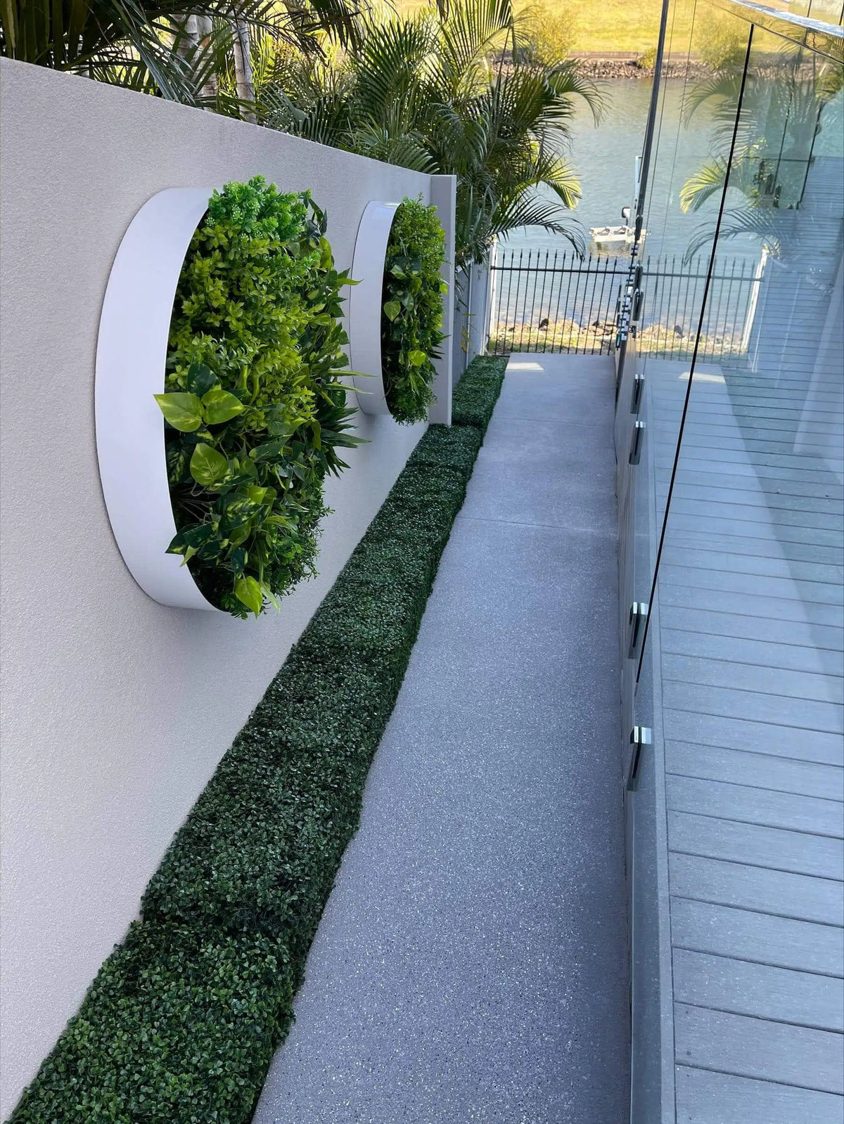 Green artificial hedge panel by Designer Plants USA, UV resistant and suitable for commercial use, with a portable hedge below.