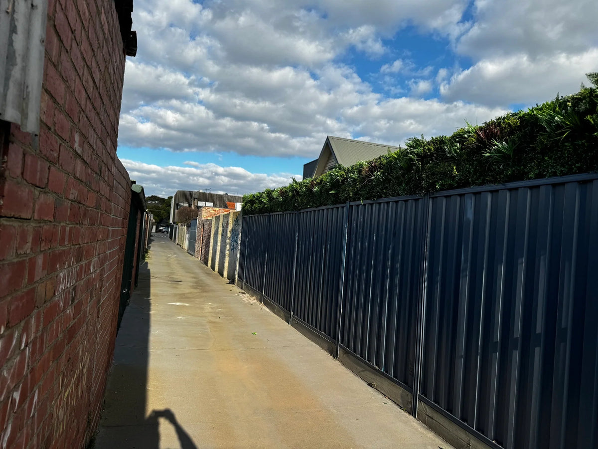 Artificial green wall panel by Designer Plants USA, 40x40 inch lush vertical garden on a fence for commercial or residential use.