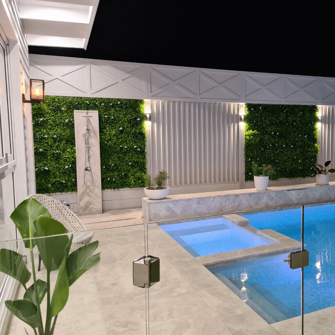 White Oasis artificial vertical garden wall panel by Designer Plants USA with built-in lights at night, UV resistant, 40x40 inches.