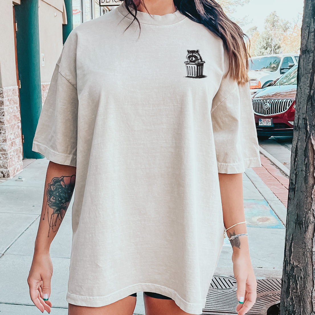 Dumpster raccoon graphic tee featuring a playful raccoon illustration on a casual T-shirt by Shop Karma Tees.
