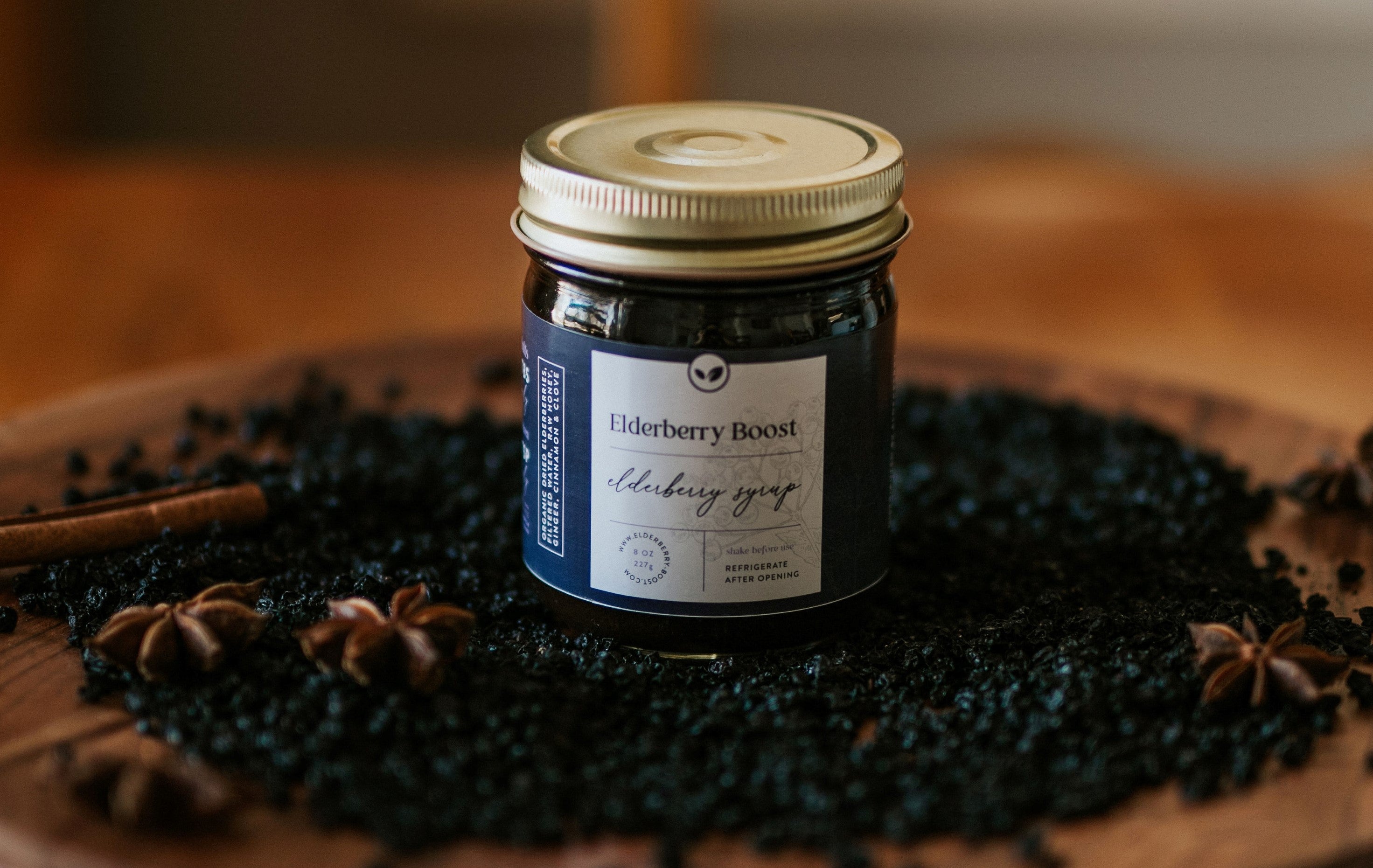 8 oz bottle of All Natural Elderberry Boost syrup by Elderberry Boost, LLC, featuring fresh elderberries in a clear glass bottle.