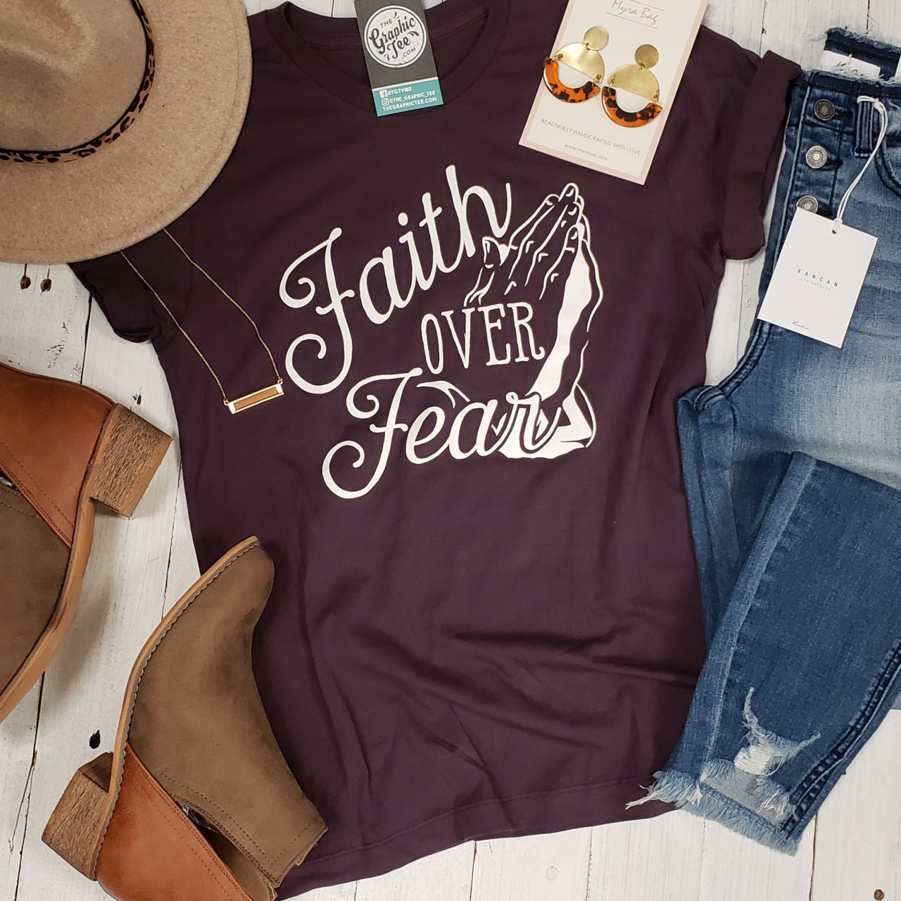 Dark purple graphic T-shirt with "Faith Over Fear" text from The Graphic Tee, showcasing a casual, inspirational design.