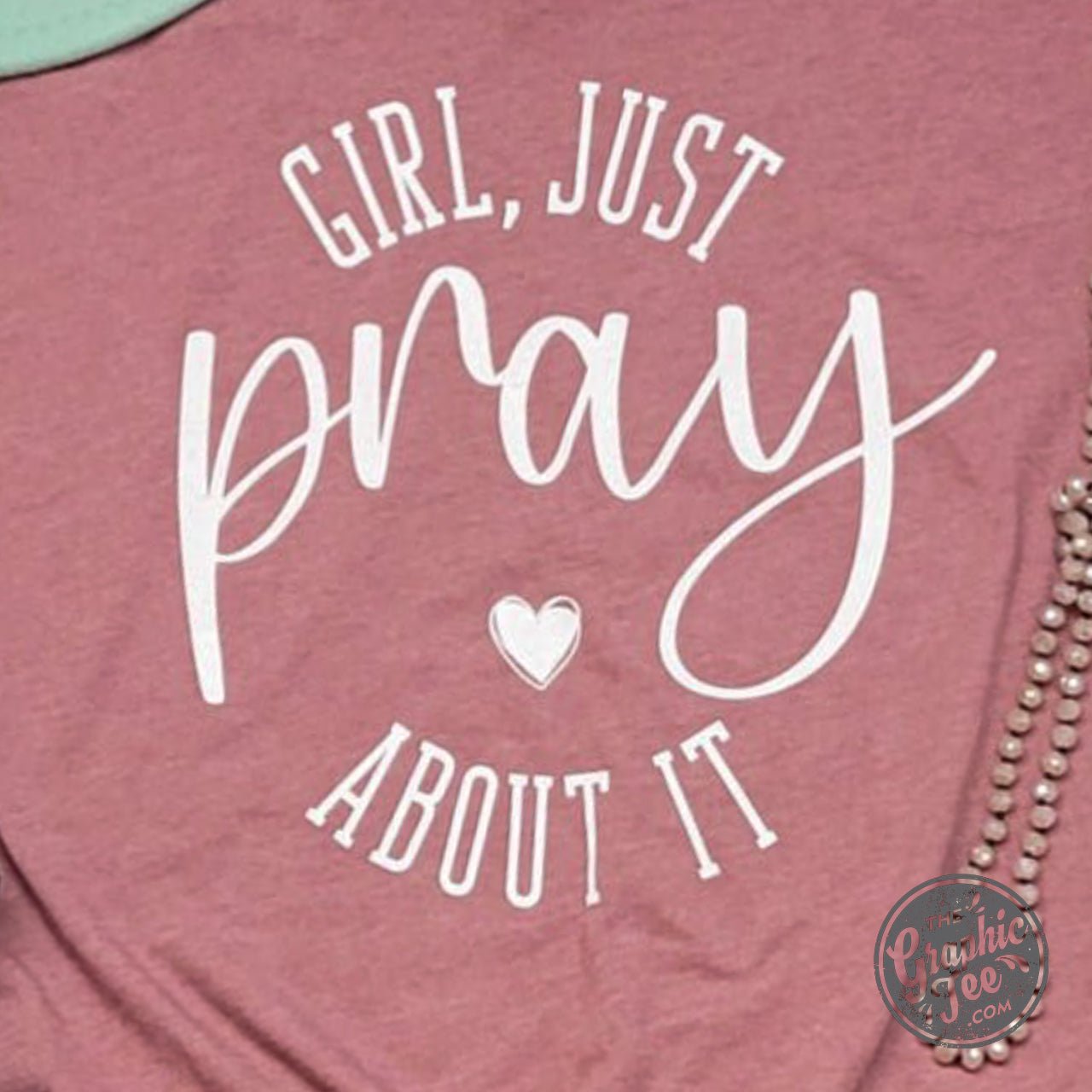 Girl wearing Heather Mauve unisex V-neck T-shirt with "Just Pray About It" graphic, from The Graphic Tee collection.