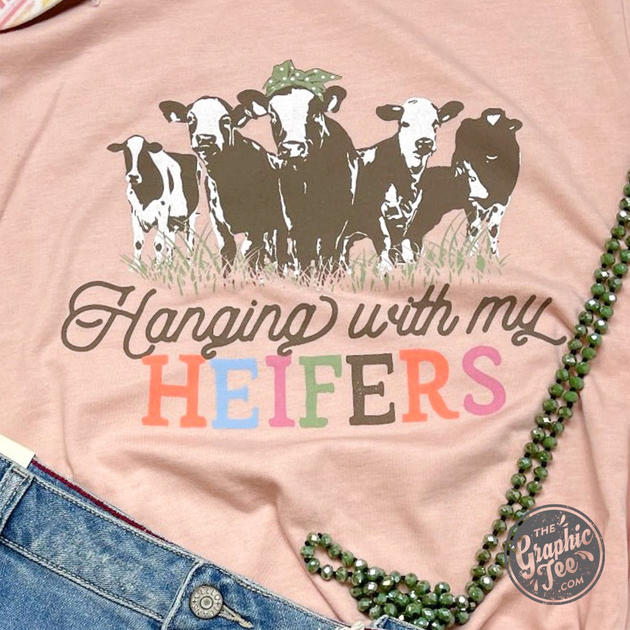 Black Hanging With My Heifers graphic T-shirt by The Graphic Tee, showing a casual crewneck tee with humorous farm-themed design.