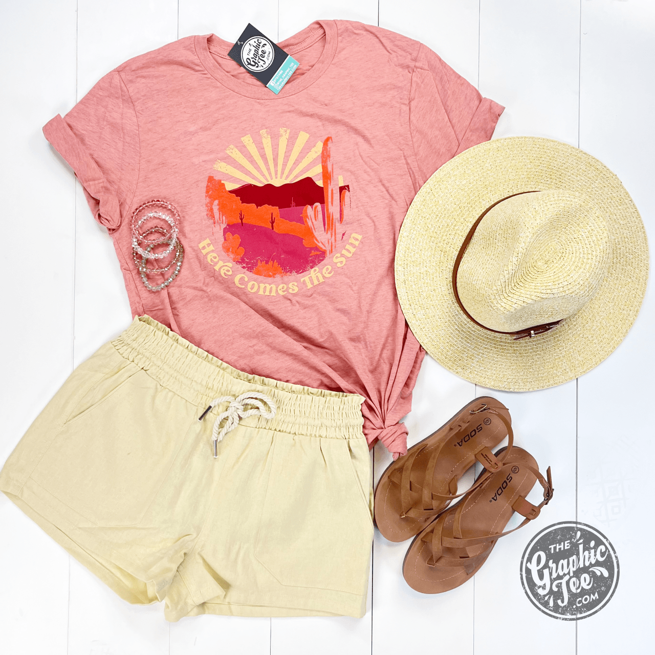 Here Comes The Sun SS Graphic Tee by The Graphic Tee, featuring a bright sun graphic on a casual short-sleeve T-shirt.