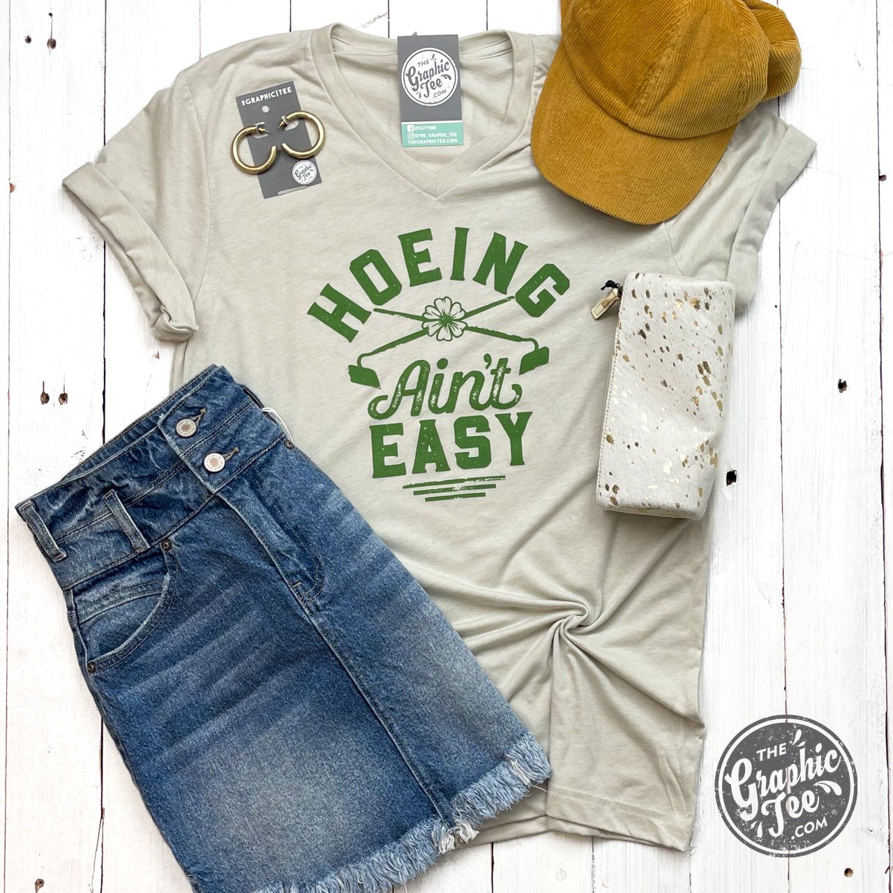 Gray SS graphic V-neck tee by The Graphic Tee featuring a gardening theme with the phrase "Hoeing Ain't Easy."