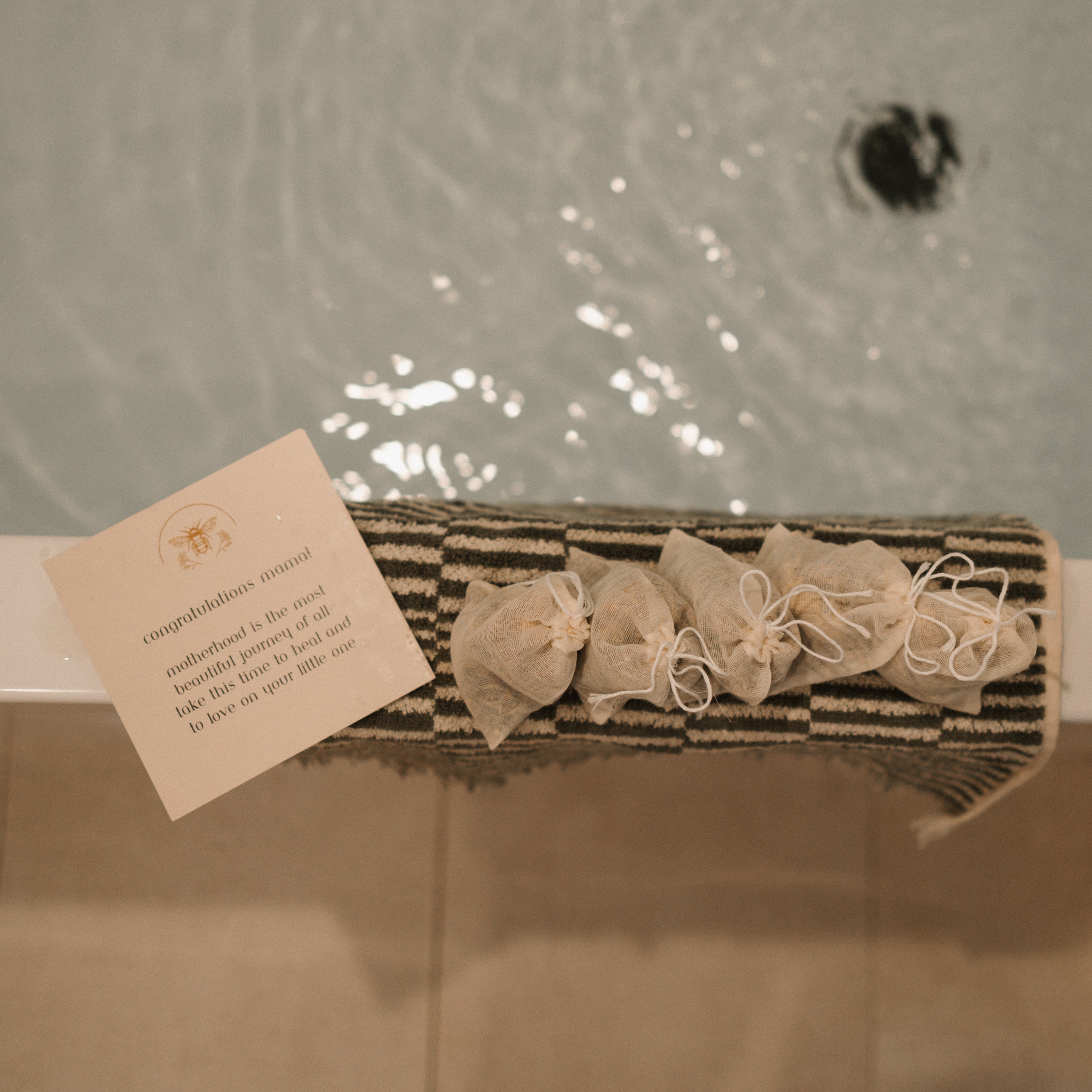 Herbal sitz bath by Honeybee Hippie for postpartum recovery, showing a herbal bath soak in a rustic wooden tub.