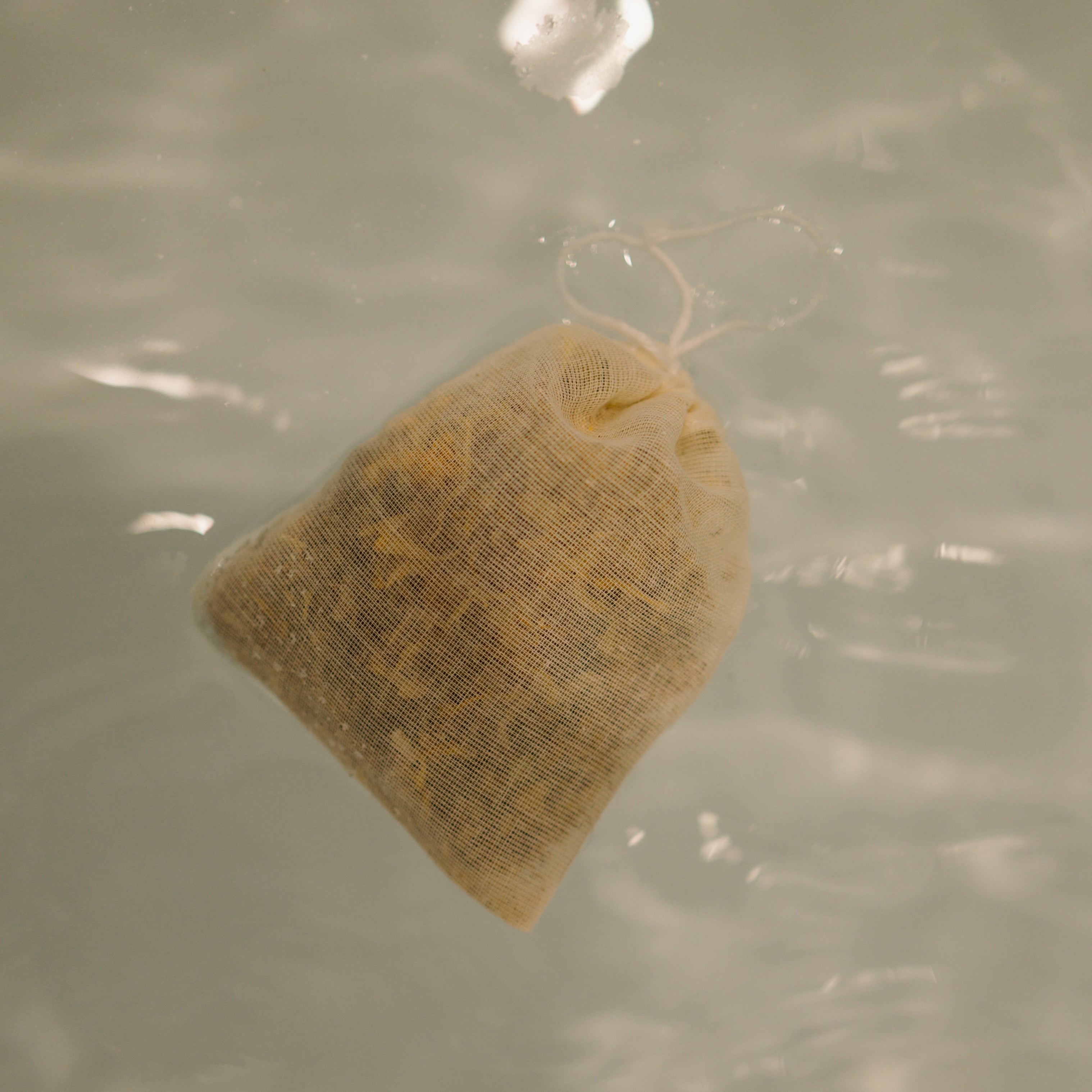 Herbal sitz bath by Honeybee Hippie for postpartum recovery, showing a herbal-filled sitz bath bowl with dried herbs inside.
