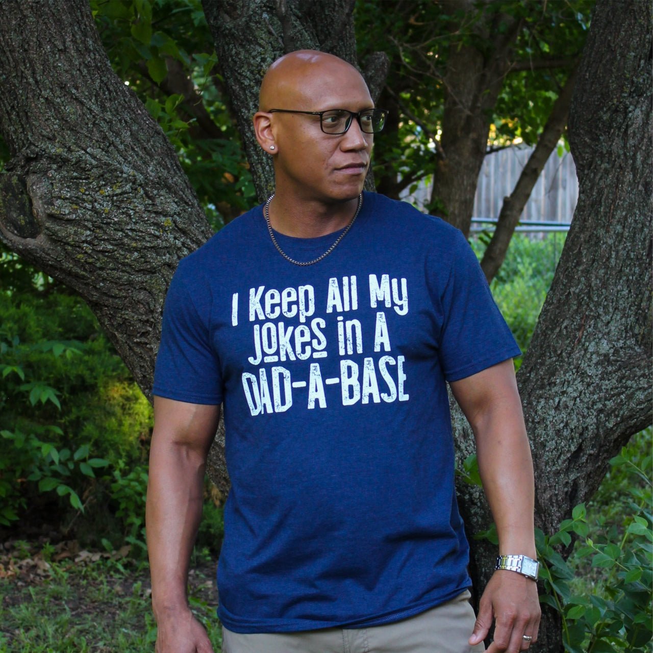 Adult graphic tee by The Graphic Tee featuring humorous "I Keep All My Jokes In A Dad-A-Base" design on a short sleeve shirt.