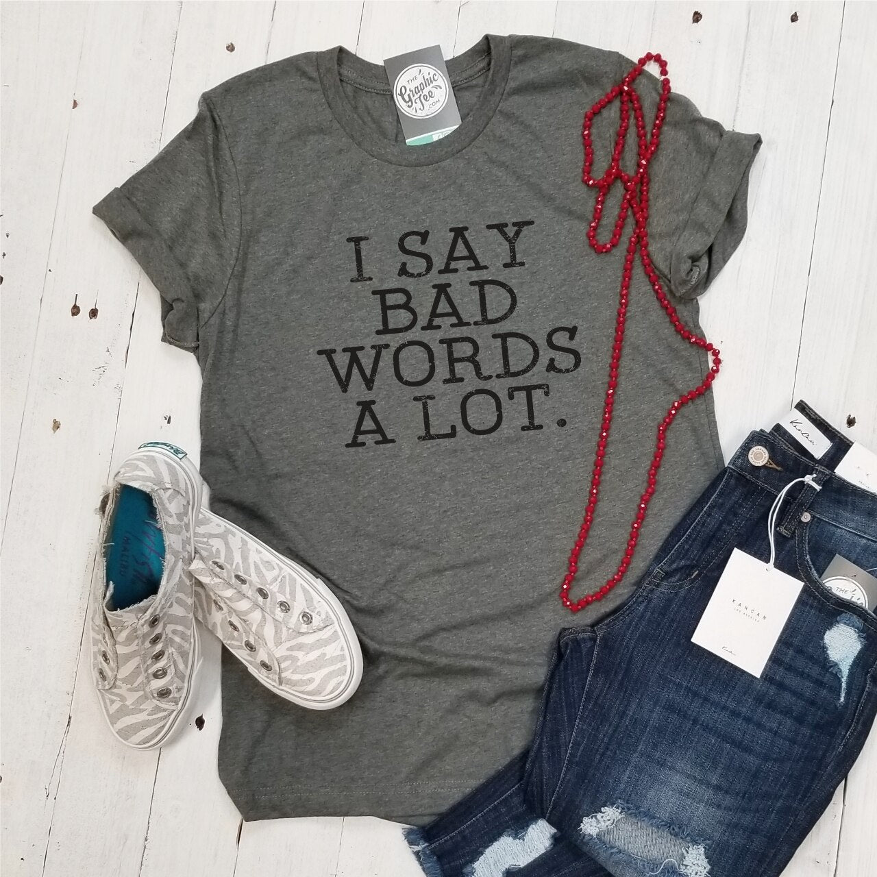 Unisex graphic T-shirt from The Graphic Tee with bold "I Say Bad Words A Lot" print in black on a white background.
