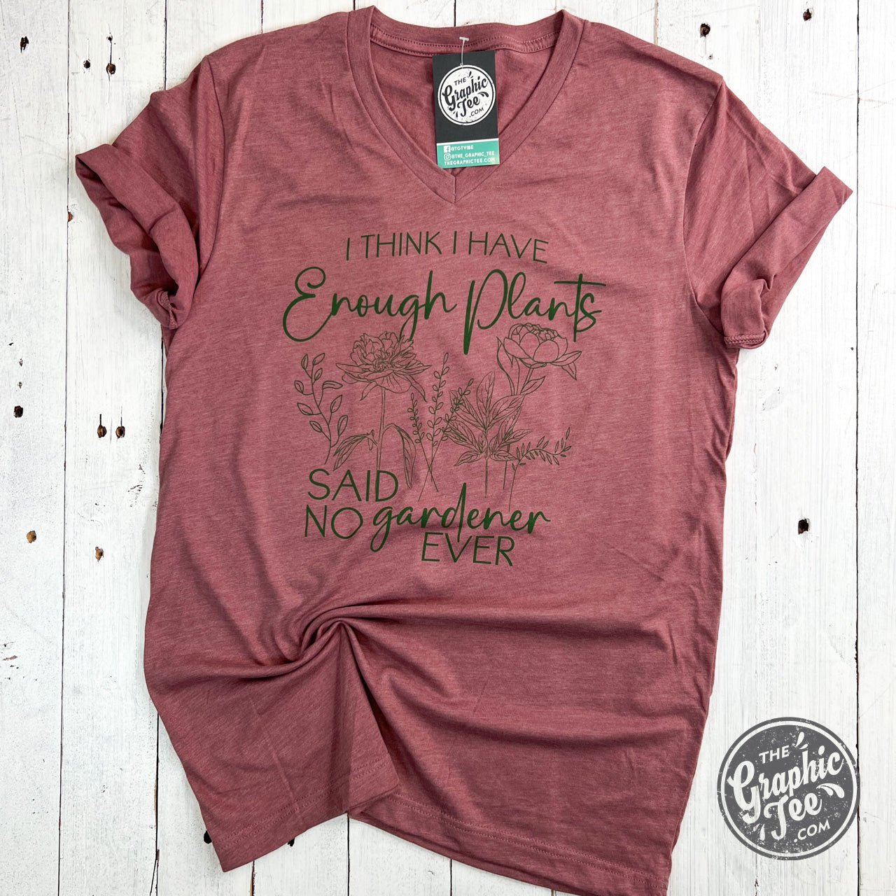 Gray V-neck graphic tee by The Graphic Tee featuring the phrase "I Think I Have Enough Plants, Said No Gardener Ever" with plant illustrations.