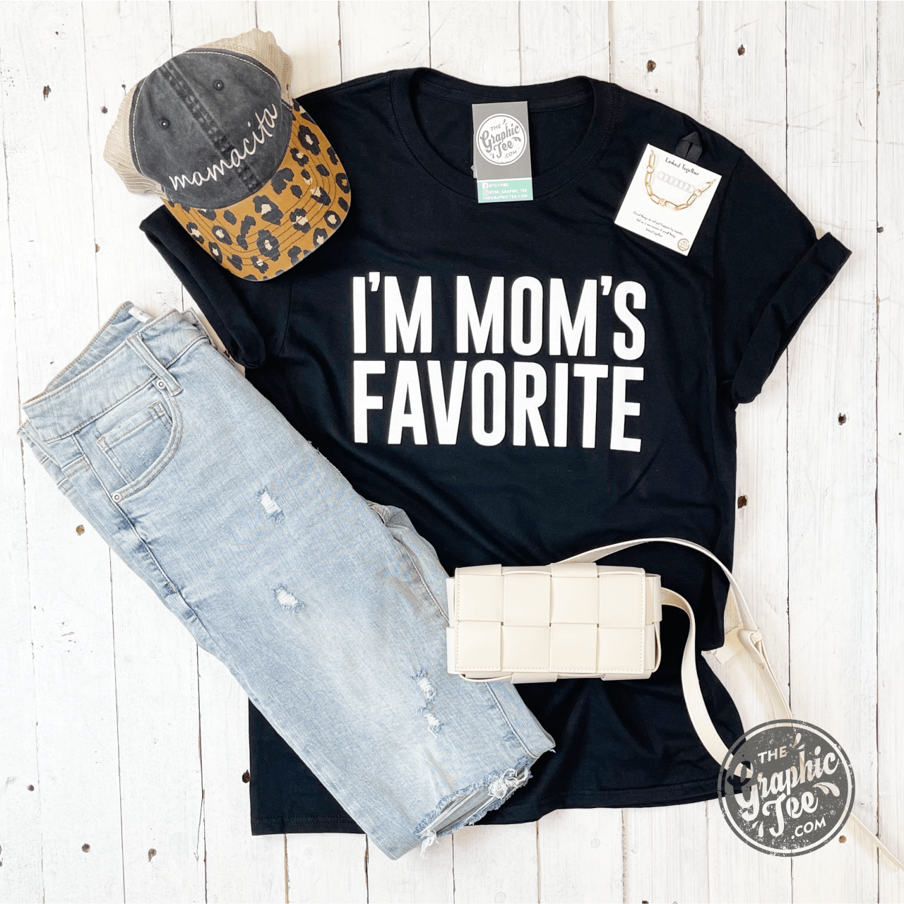 Black short-sleeve graphic tee for women with "I'm Mom's Favorite" print by The Graphic Tee. Casual, stylish women's T-shirt.