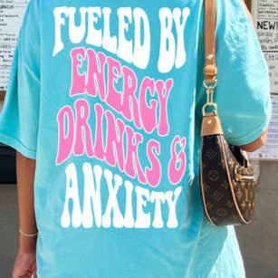 Black graphic t-shirt featuring "Fueled By Energy Drinks and Anxiety" design from Shop Karma Tees, with bold text and casual fit.