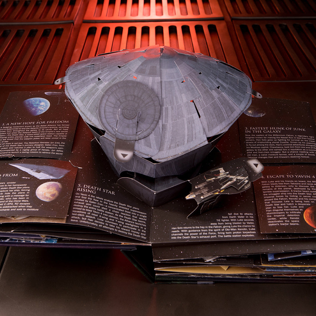 Hardcover copy of Star Wars: The Ultimate Pop-Up Galaxy by Insight Editions, showcasing intricate pop-up galaxy scenes inside.