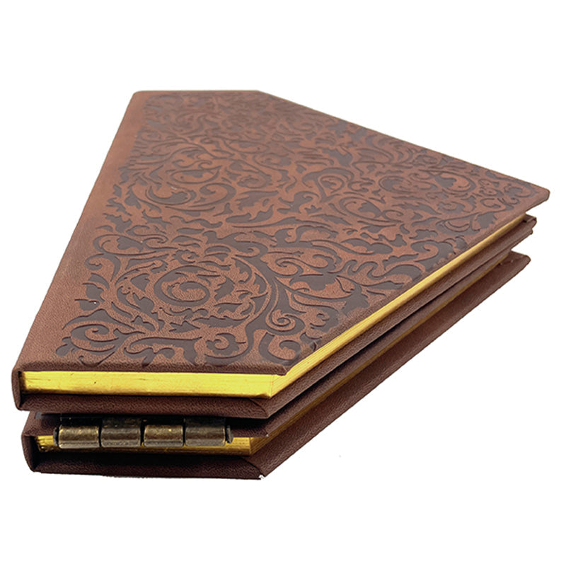 Open hardcover journal titled "Wicked: The Grimmerie" with decorated pages and ornate design, published by Insight Editions.
