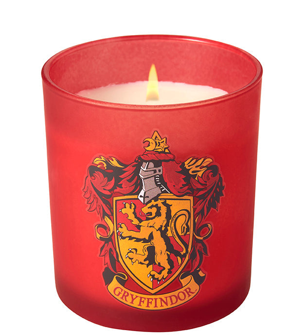 Gryffindor scented glass candle from Harry Potter home goods set by Insight Editions, with a clear glass container and Gryffindor emblem.