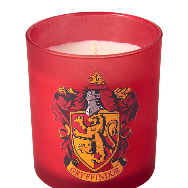 Gryffindor scented glass candle from Harry Potter, Insight Editions home decor with a decorative label and flickering flame.