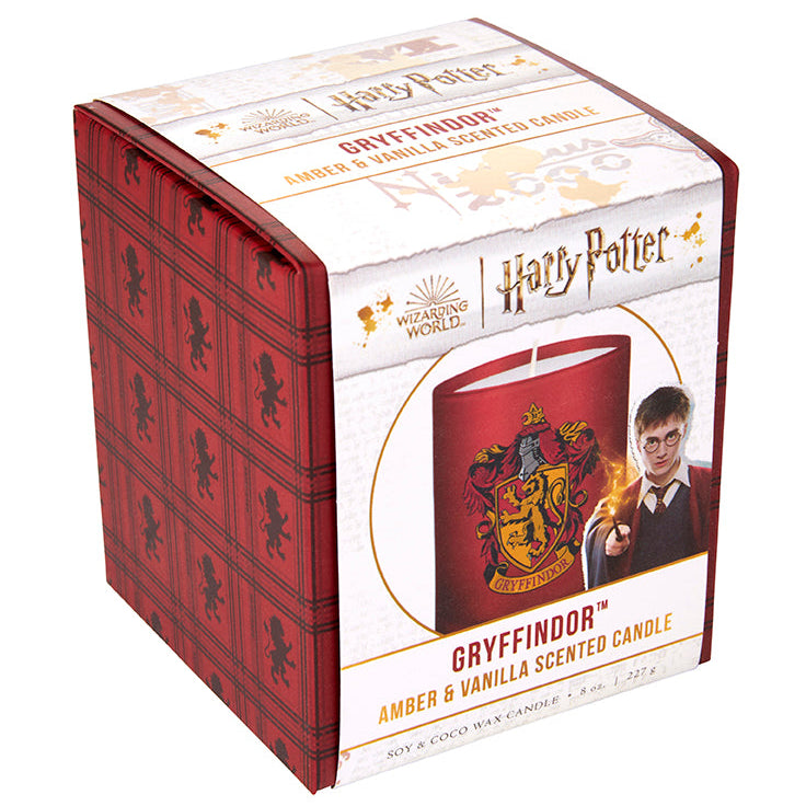 Gryffindor scented glass candle from Harry Potter home goods collection with a decorative label and flickering flame.