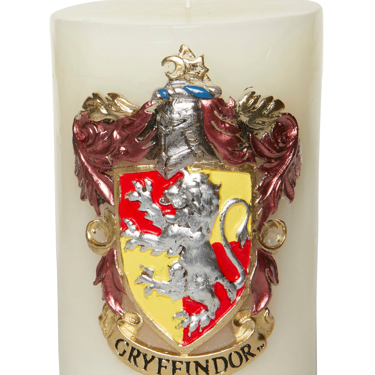 Gryffindor insignia sculpted candle from Harry Potter home goods collection, featuring detailed Hogwarts house crest in warm tones.