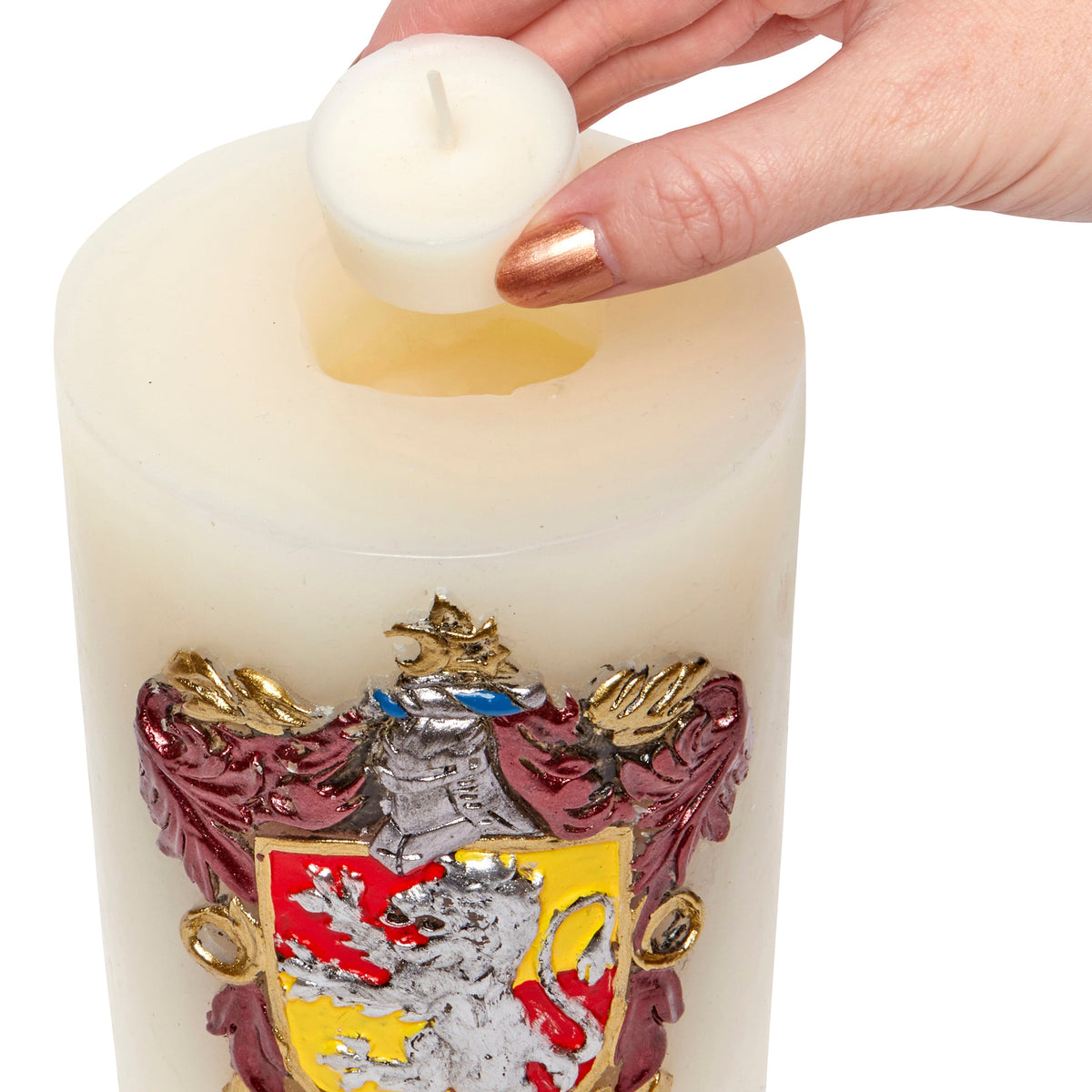 Gryffindor insignia candle from Harry Potter featuring a sculpted Hogwarts house crest in a home decor setting.