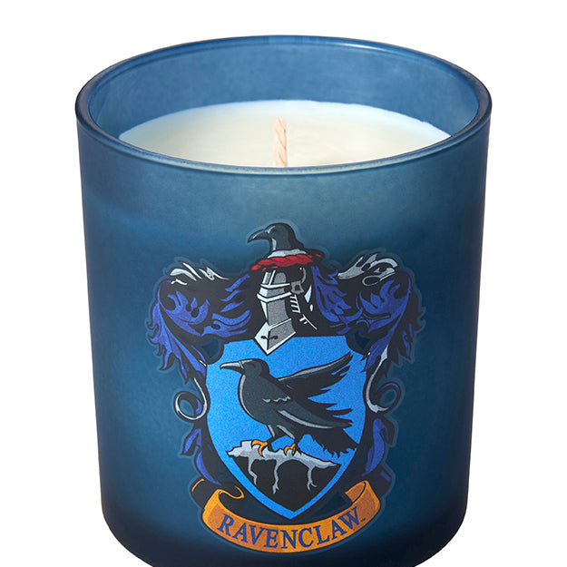 Ravenclaw scented glass candle from Harry Potter home goods collection by Insight Editions, featuring blue glass and Ravenclaw emblem.