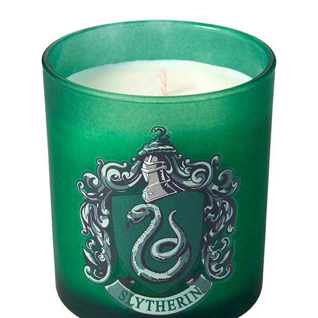 Slytherin scented glass candle from Harry Potter home goods collection by Insight Editions, featuring green candle inside a Slytherin-themed glass.