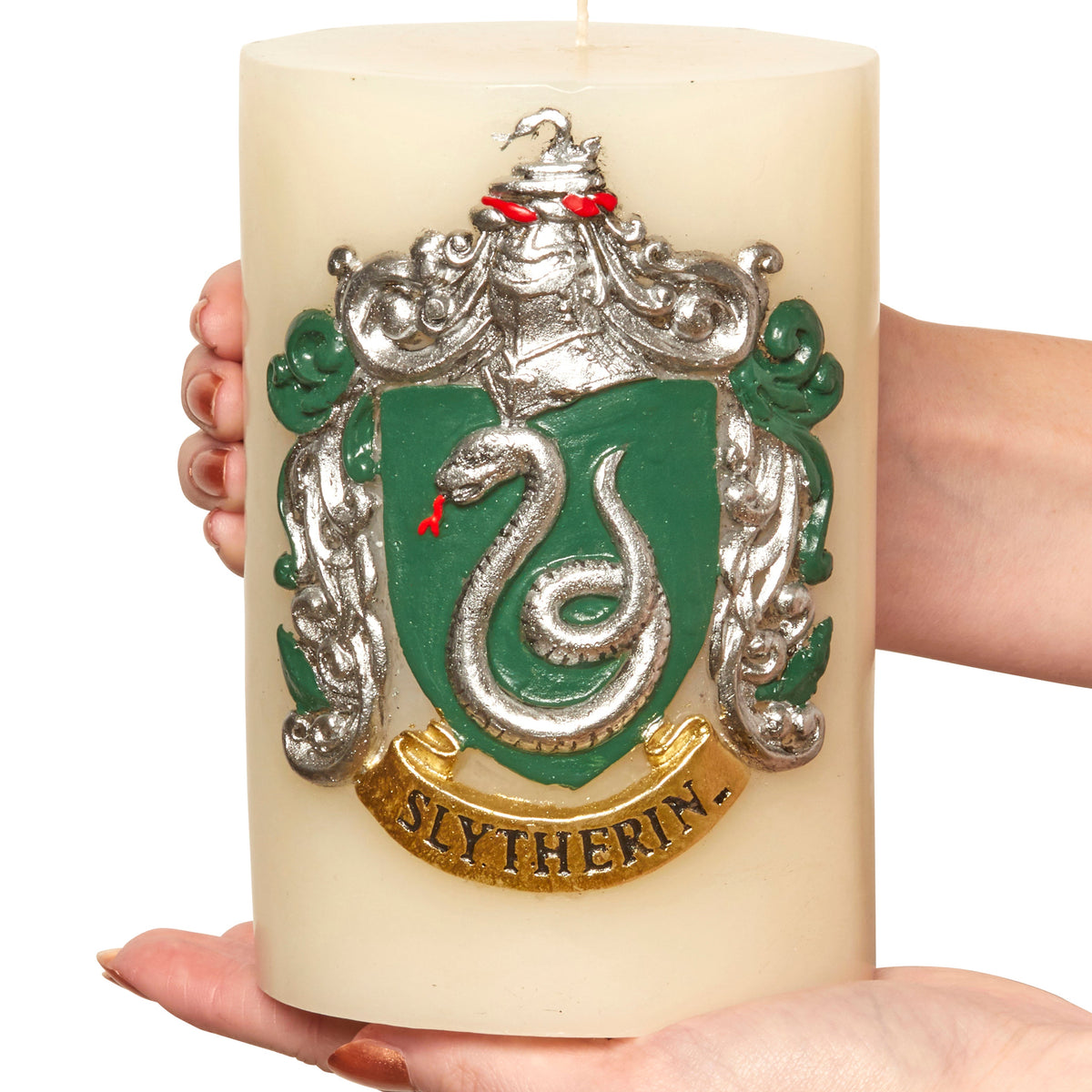 Slytherin insignia candle from Harry Potter series, with sculpted Slytherin crest on a decorative home goods candle by Insight Editions.