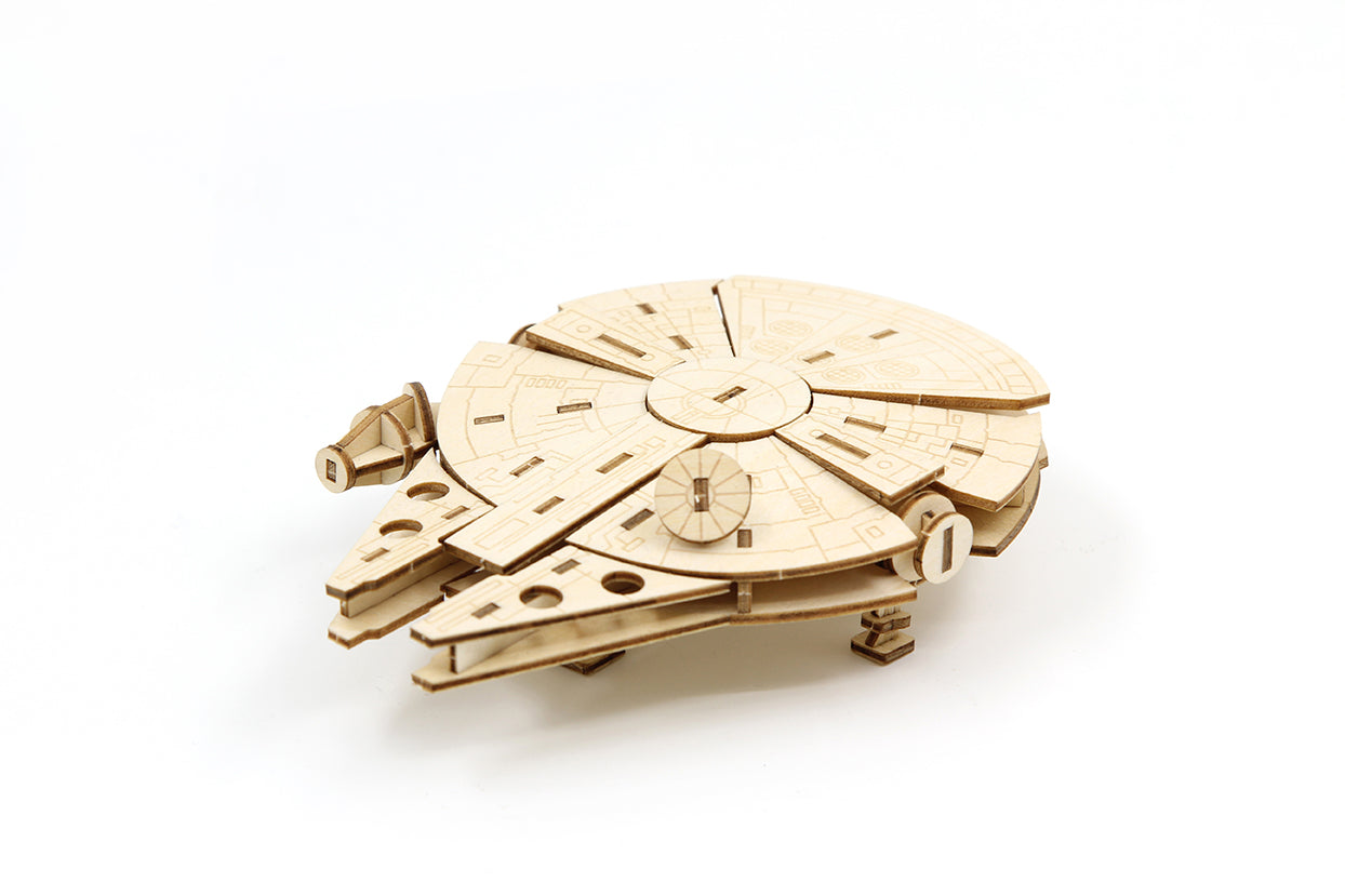 IncrediBuilds Star Wars Millennium Falcon 3D wood model kit with instruction book, featuring detailed wooden spaceship craft.