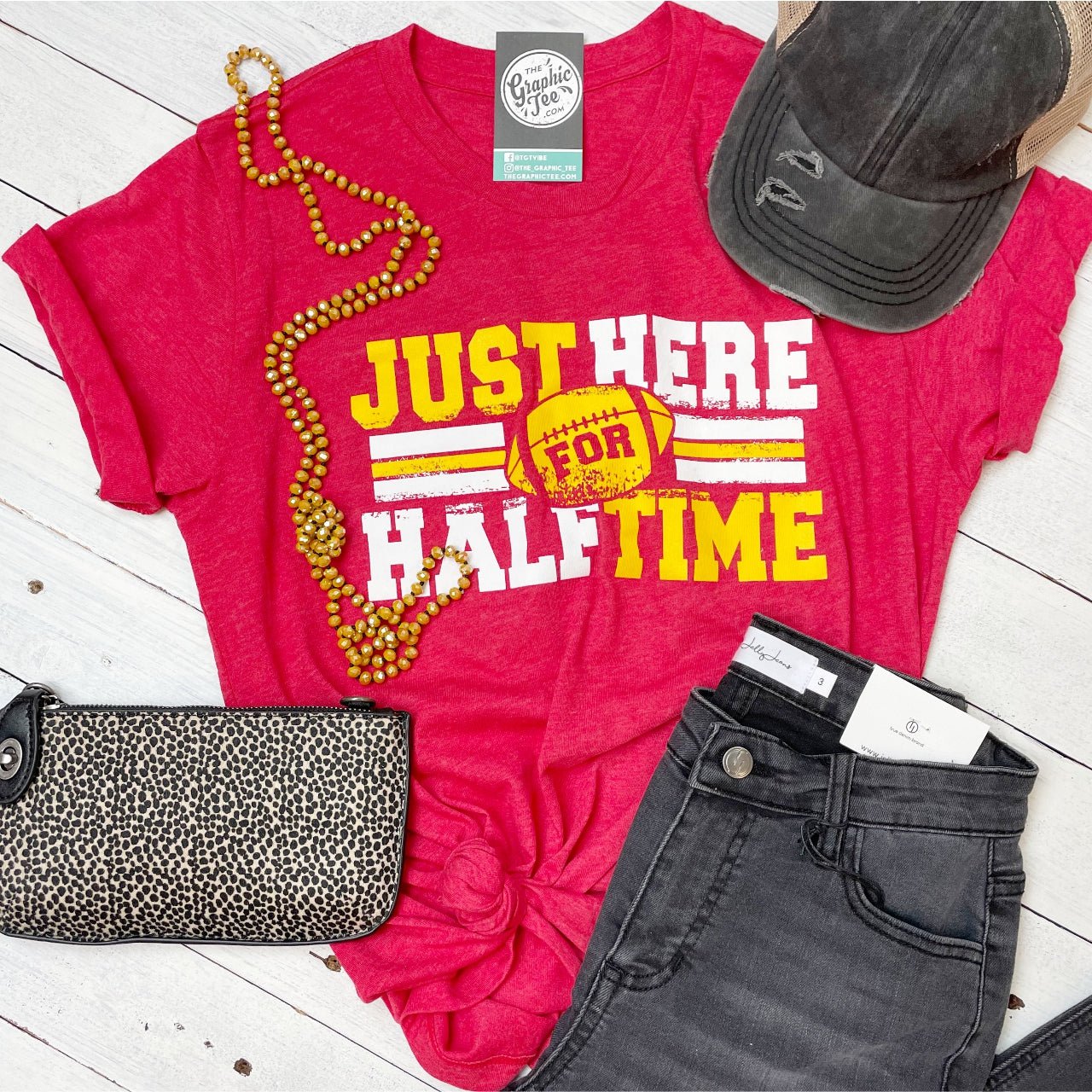 Unisex graphic tee by The Graphic Tee featuring "Just Here For Halftime" design, casual short-sleeve t-shirt on a plain background.