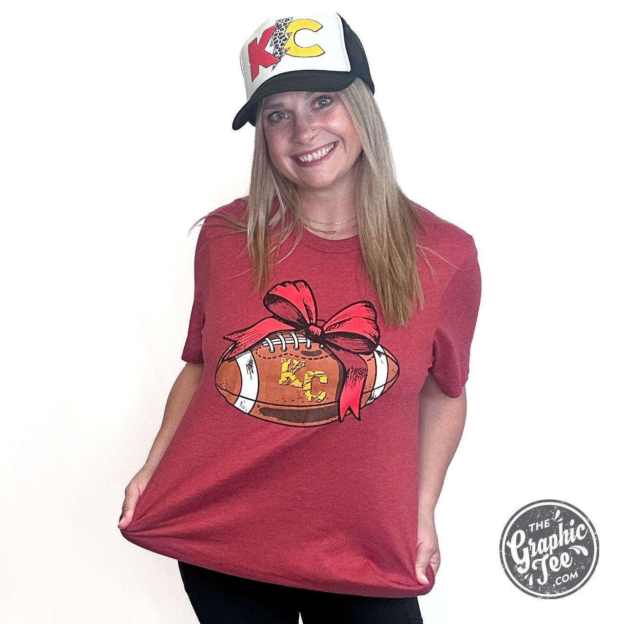 KC Football Bow Heather Cardinal short sleeve crewneck tee by The Graphic Tee, featuring a football-themed graphic on a heathered fabric.