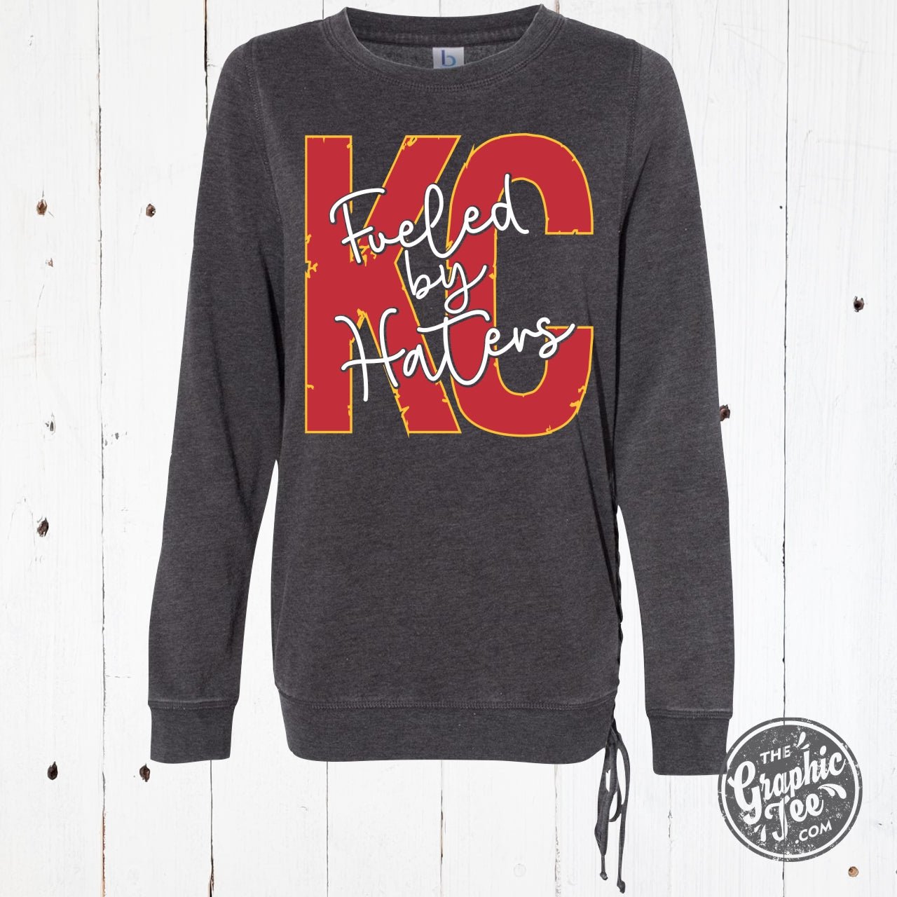 Mineral washed ladies lace-up sweatshirt by The Graphic Tee featuring bold "Fueled By Haters" print, casual and stylish shirt.