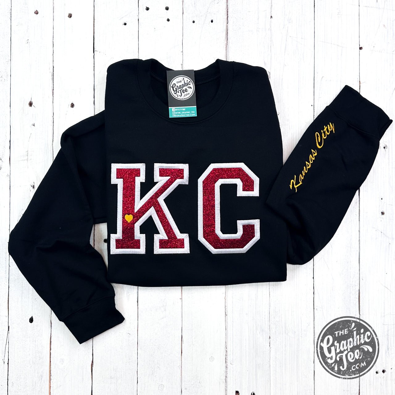 Black crewneck sweatshirt with red glitter applique design, from The Graphic Tee, featuring a stylish and casual look.