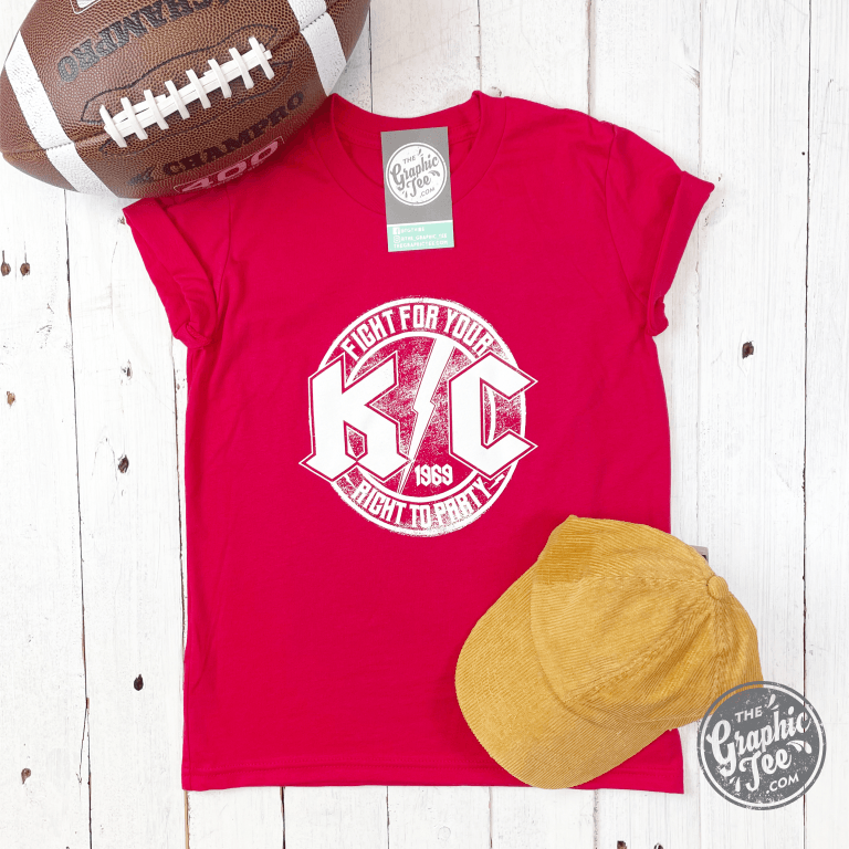 Red youth short sleeve graphic tee from KC Rock by The Graphic Tee, featuring bold rock-themed design on the front.