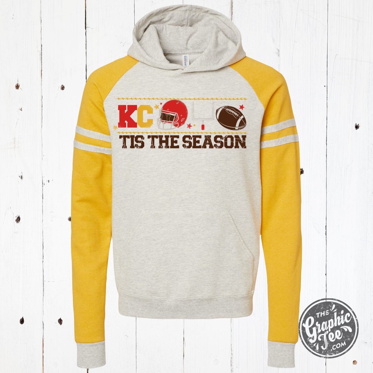 KC Tis the Season varsity hoodie from The Graphic Tee, featuring festive holiday graphic and comfortable sweatshirt style.