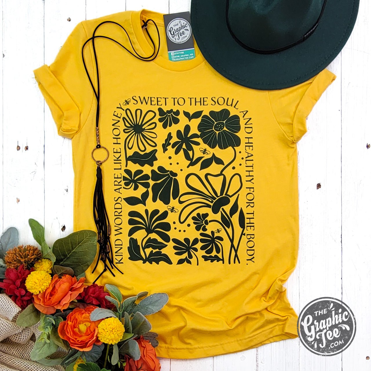 Heather golden yellow short sleeve graphic tee by The Graphic Tee featuring uplifting "Kind Words" design on soft cotton fabric.