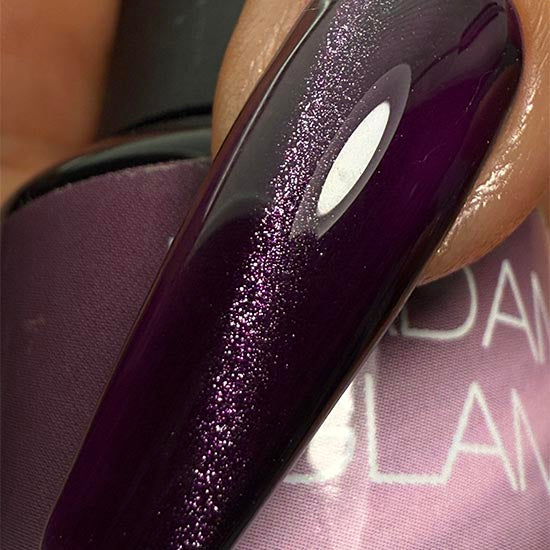 Madam Glam Hocus Plum nail polish bottle with purple and plum shades on a white background.