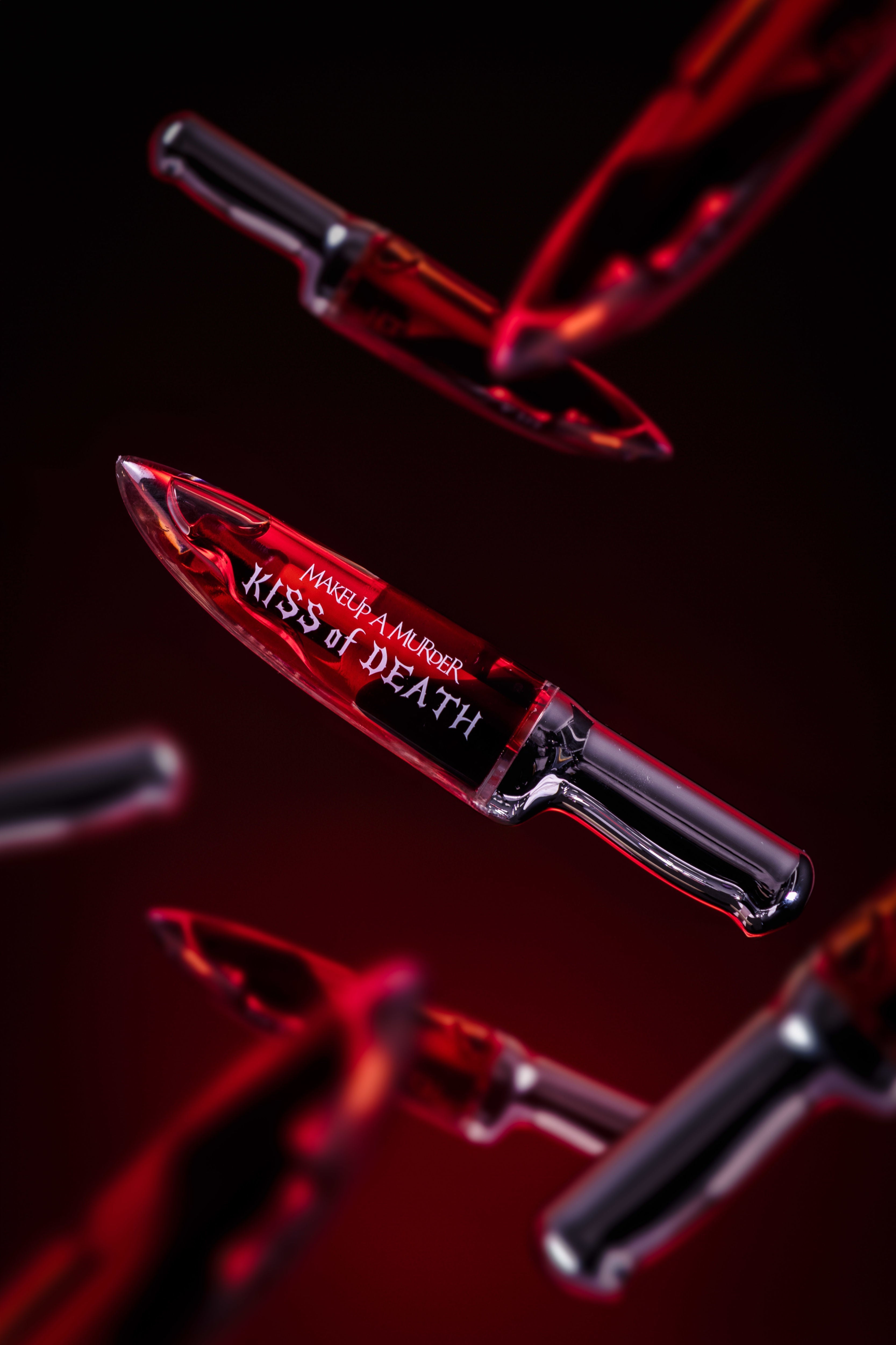 KISS of DEATH Bloody Lip Oils full collection by Makeup A Murder, INC featuring vibrant, blood-red lip oil tubes arranged together.