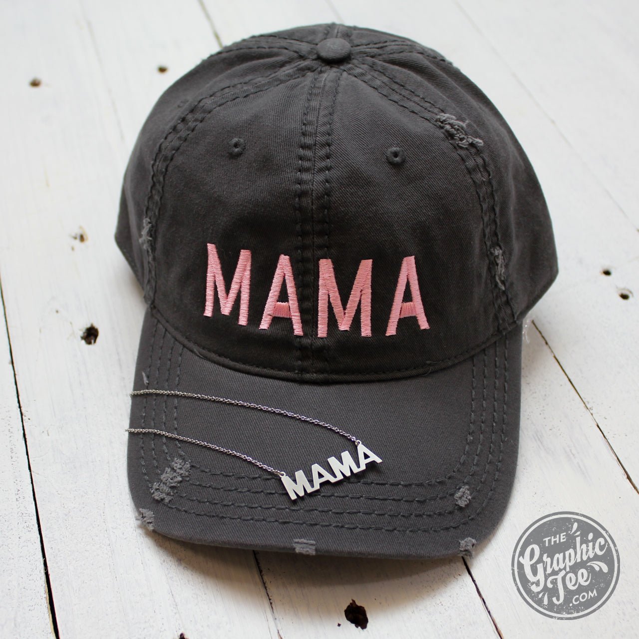 Charcoal distressed canvas cap with "Mama" embroidered, styled as a casual hat from The Graphic Tee brand.