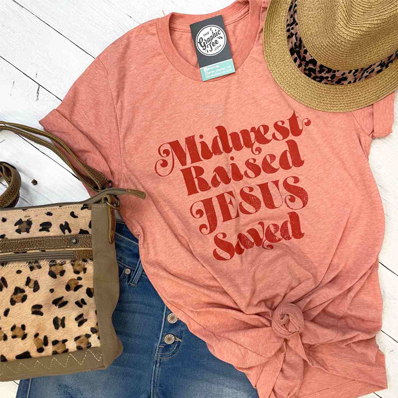 Unisex graphic T-shirt from The Graphic Tee featuring Midwest Raised and Jesus Saved design, casual apparel for men and women.