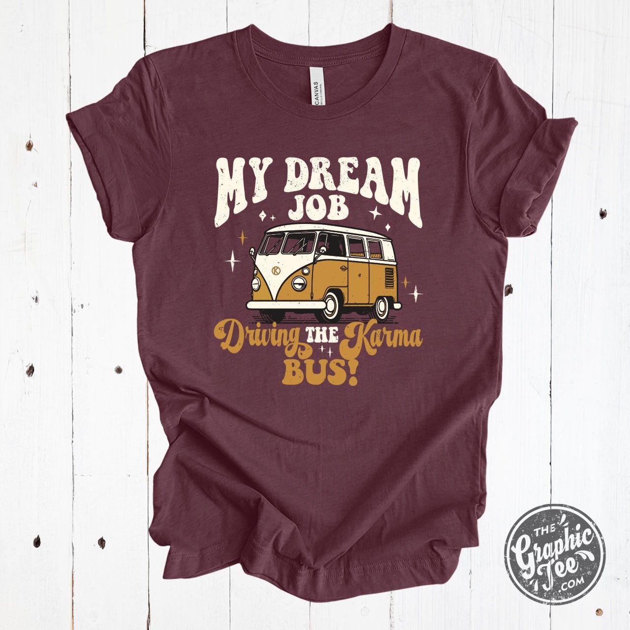 Heather maroon short sleeve graphic tee featuring "My Dream Job...Driving The Karma Bus" text from The Graphic Tee brand.