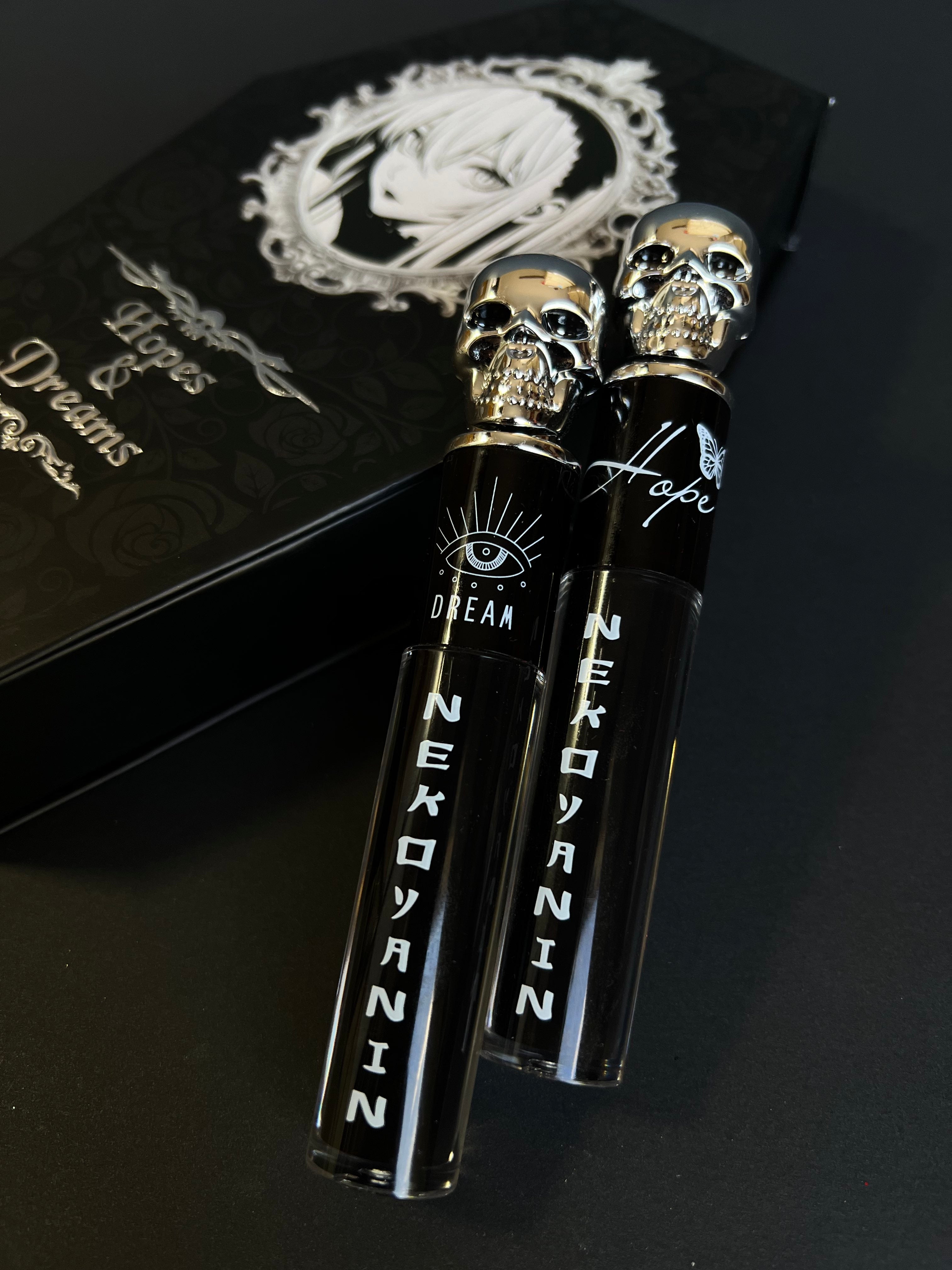 Nekoyanin Hopes and Dreams black liquid lipstick and lip gloss duo, featuring sleek black packaging and applicators.