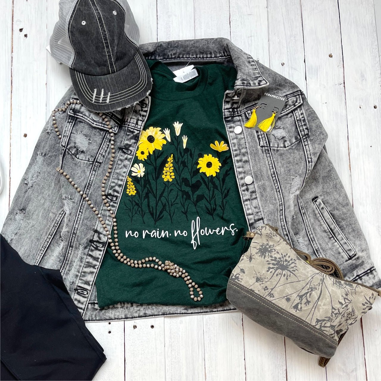 The Graphic Tee No Rain No Flowers SS graphic T-shirt featuring a vibrant floral and rain design on a casual cotton tee.
