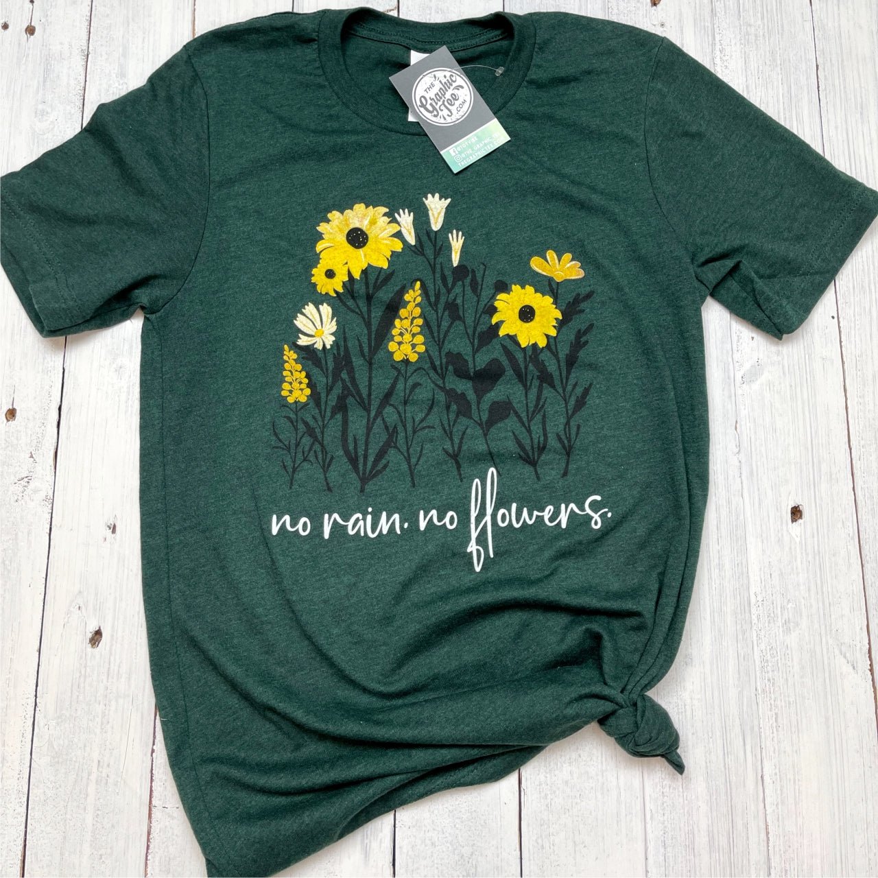 The Graphic Tee No Rain No Flowers SS graphic t-shirt with a colorful floral design on the front.