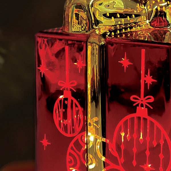 Old World Christmas lit ornamental glass gift box with intricate design and vibrant colors, perfect for holiday decor.