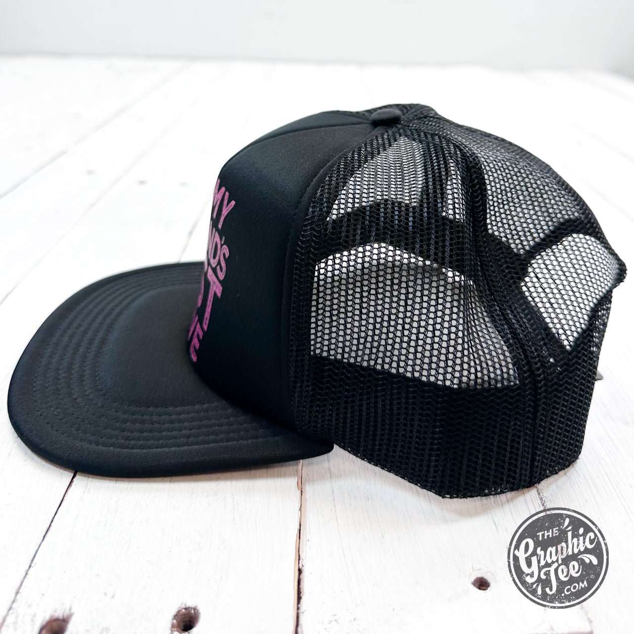 Black foam trucker cap with humorous "On My Husband's Last Nerve" slogan from The Graphic Tee, casual and stylish headwear.