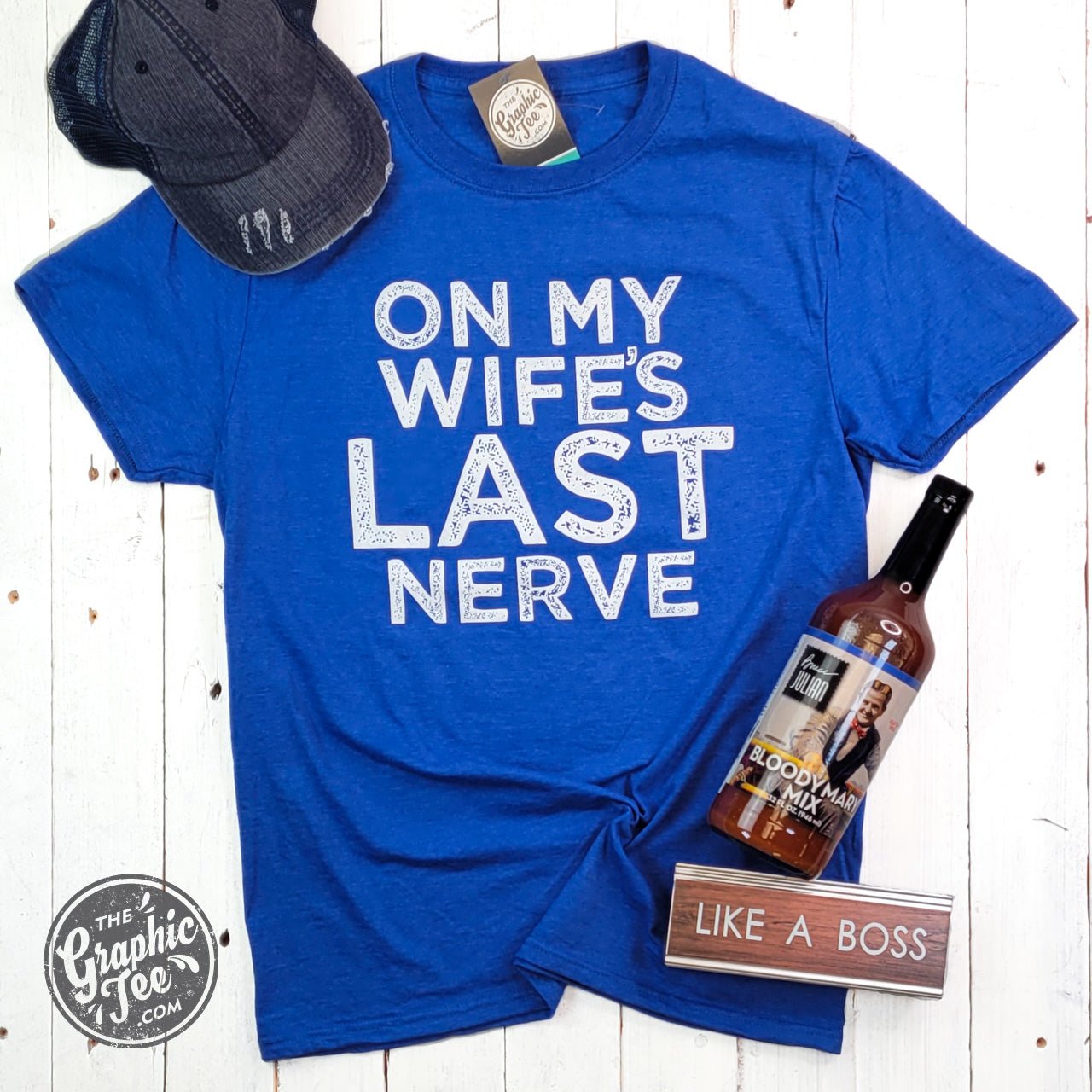 Unisex SS Graphic Tee by The Graphic Tee with humorous "On My Wife's Last Nerve" design on light-colored fabric.