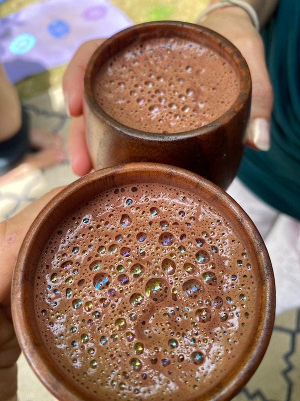Ora Cacao Cups by Ora Cacao, showing packaged organic cacao cups arranged on a wooden surface.